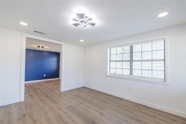 empty room with wood-type flooring, a textured ceiling, and ceiling fan