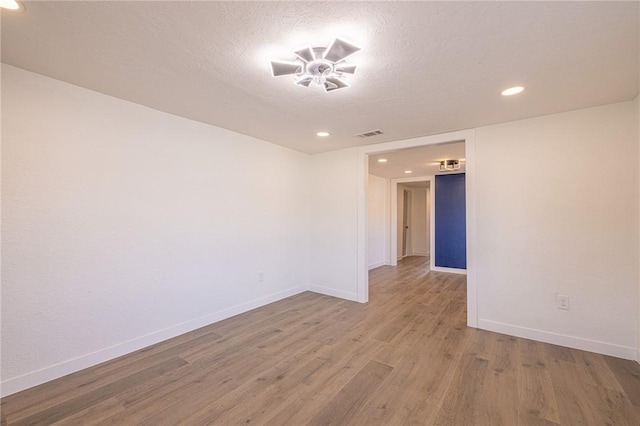 unfurnished room featuring hardwood / wood-style flooring and a textured ceiling