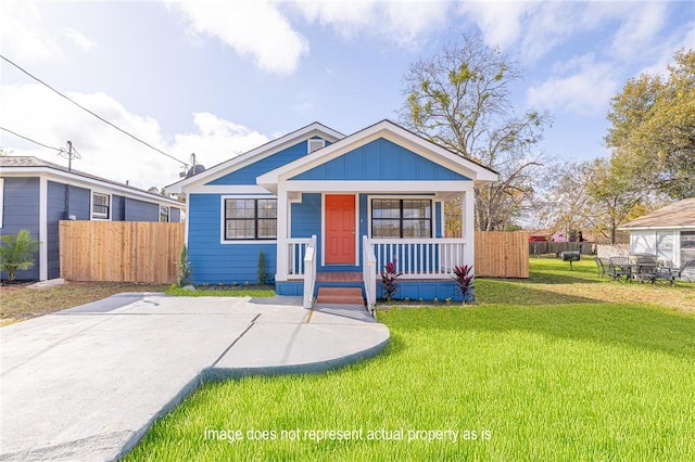 bungalow-style home featuring a front yard and covered porch