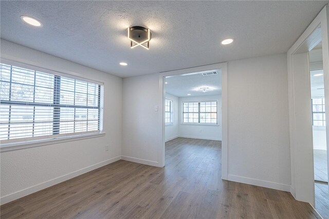 unfurnished room featuring hardwood / wood-style floors and a textured ceiling