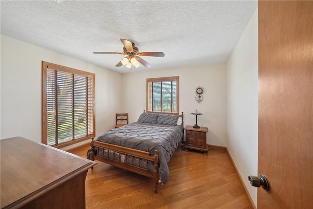 22349 Fm 359th Rd, Hempstead, TX 77445 - bedroom featuring light wood-style flooring, baseboards, a textured ceiling, and ceiling fan