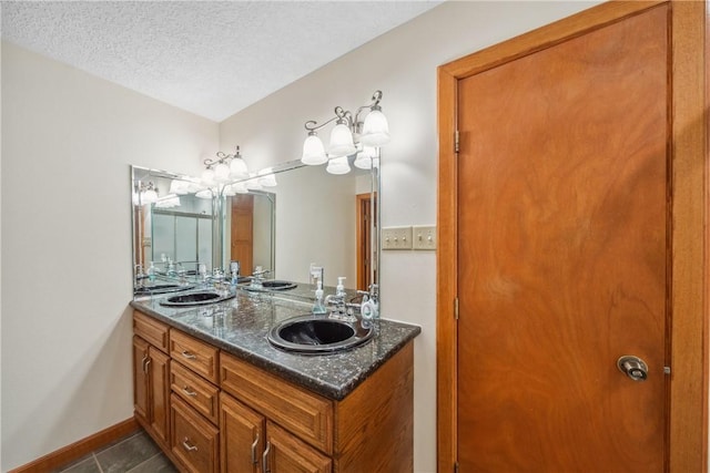 22349 Fm 359th Rd, Hempstead, TX 77445 - full bathroom with double vanity, a textured ceiling, tile patterned flooring, and baseboards