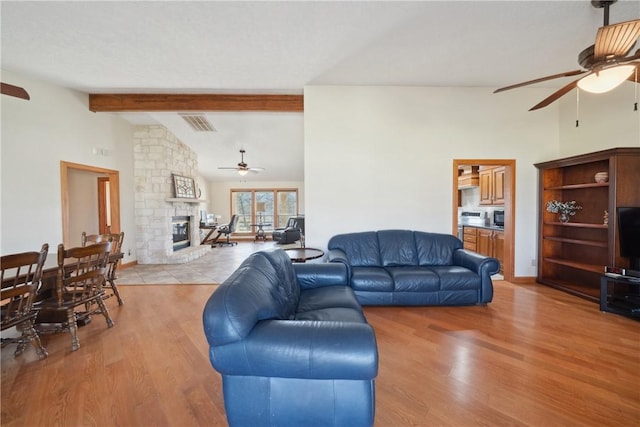 22349 Fm 359th Rd, Hempstead, TX 77445 - living room featuring a ceiling fan, a fireplace, light wood-style flooring, beamed ceiling, and high vaulted ceiling