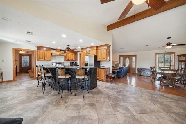 22349 Fm 359th Rd, Hempstead, TX 77445 - kitchen with ceiling fan, stainless steel refrigerator with ice dispenser, an island with sink, beamed ceiling, and a breakfast bar