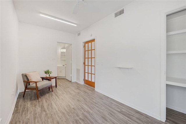 sitting room with hardwood / wood-style floors and ceiling fan