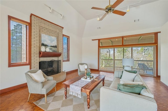 living room with a fireplace, high vaulted ceiling, rail lighting, and ceiling fan