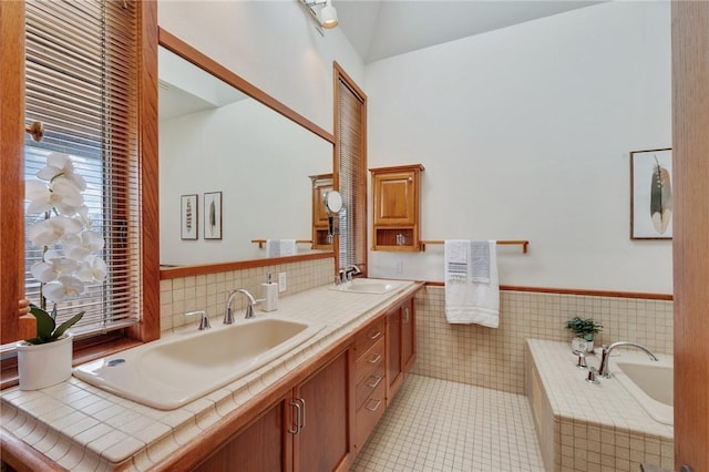 bathroom featuring vanity, a tub, tile walls, and tile patterned floors