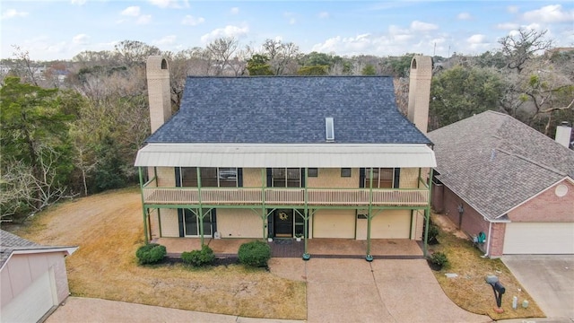 exterior space featuring a garage, covered porch, and a front yard