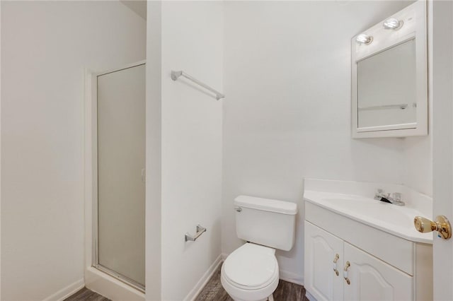 bathroom featuring vanity, hardwood / wood-style floors, a shower with door, and toilet