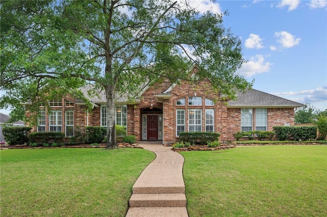view of front of property featuring brick siding and a front yard