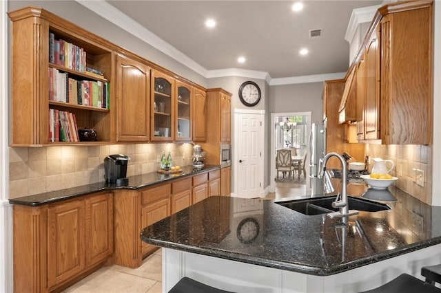 kitchen with visible vents, open shelves, a peninsula, a sink, and backsplash