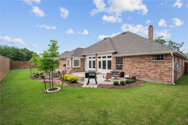 back of house featuring a chimney, roof with shingles, a patio area, brick siding, and a fenced backyard