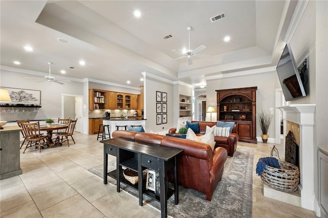 living area with visible vents, a ceiling fan, a raised ceiling, and recessed lighting