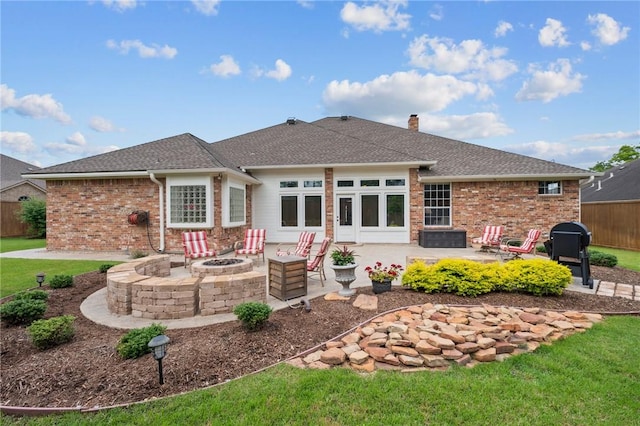 back of property with a chimney, brick siding, fence, a patio, and a fire pit