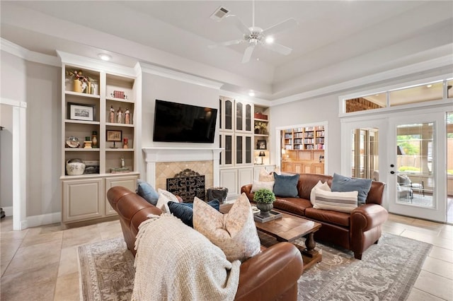 living area featuring visible vents, crown molding, a tile fireplace, a ceiling fan, and light tile patterned floors