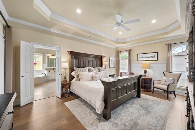 bedroom featuring ornamental molding, a raised ceiling, and multiple windows
