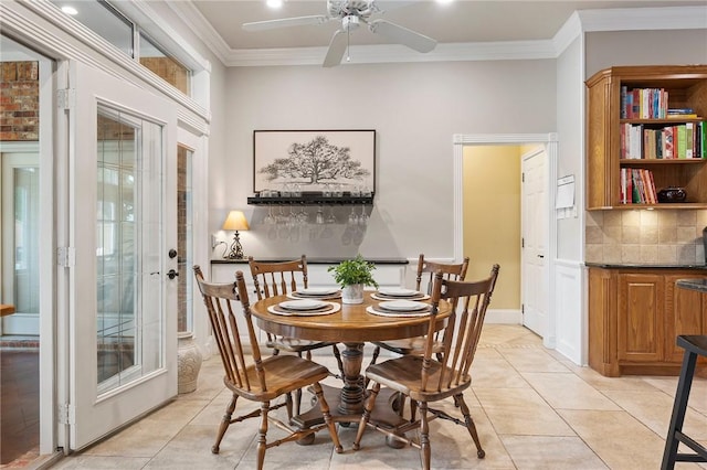 dining space featuring crown molding, light tile patterned floors, and ceiling fan