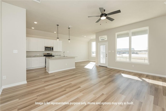 unfurnished living room featuring ceiling fan, light hardwood / wood-style floors, and sink