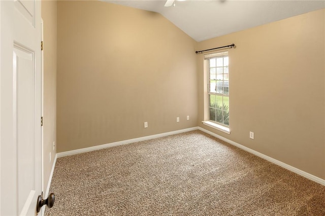 carpeted spare room featuring vaulted ceiling, baseboards, and ceiling fan