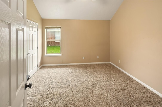 unfurnished bedroom with lofted ceiling, carpet flooring, and baseboards