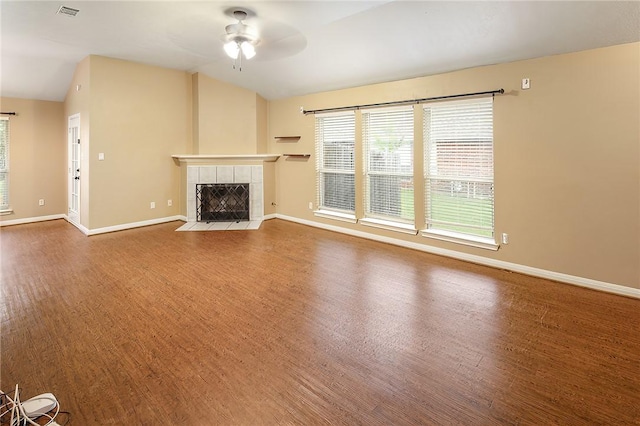 unfurnished living room featuring wood finished floors, a tile fireplace, ceiling fan, healthy amount of natural light, and lofted ceiling
