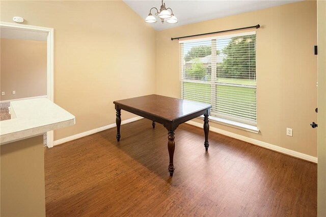 dining area with baseboards, a chandelier, wood finished floors, and vaulted ceiling