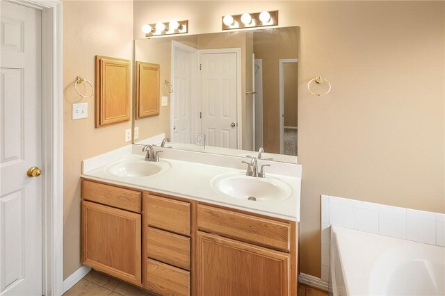 full bathroom featuring a bath, double vanity, tile patterned floors, and baseboards