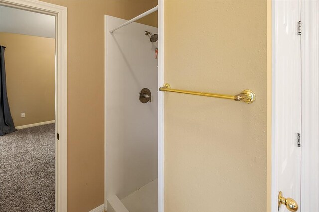 full bath featuring a stall shower and baseboards