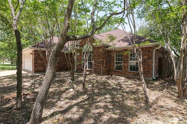 705 Summerglen Dr, College Station, TX 77840 - view of home's exterior with brick siding, an attached garage, a shingled roof, and concrete driveway