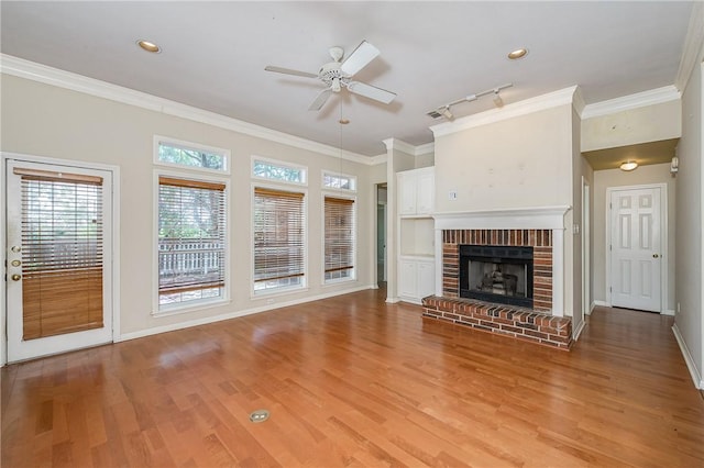 705 Summerglen Dr, College Station, TX 77840 - unfurnished living room with light wood-style floors, ceiling fan, crown molding, a brick fireplace, and recessed lighting