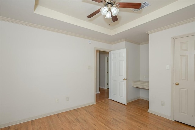 705 Summerglen Dr, College Station, TX 77840 - unfurnished bedroom with a tray ceiling, wood finished floors, and a ceiling fan