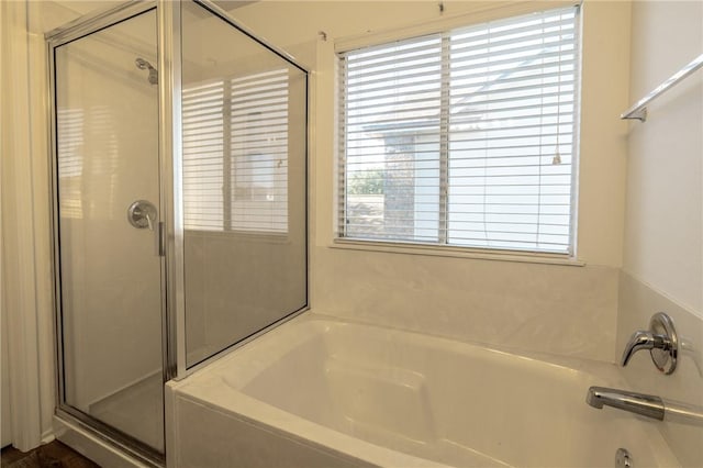 bathroom featuring independent shower and bath and a healthy amount of sunlight