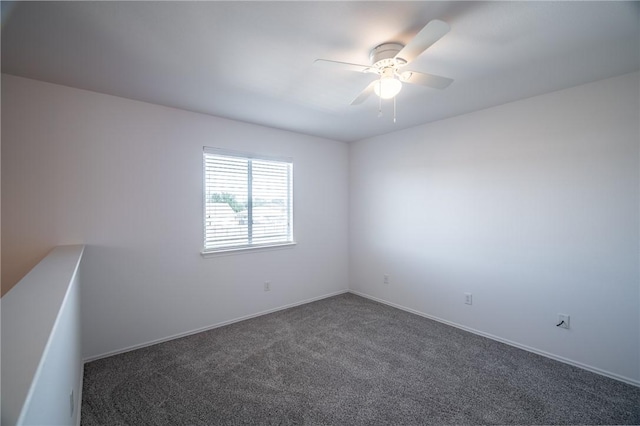 empty room with ceiling fan and dark carpet