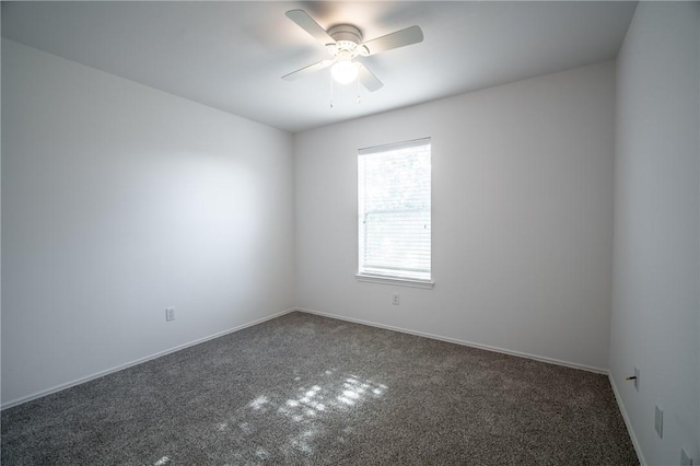 empty room featuring ceiling fan and dark colored carpet