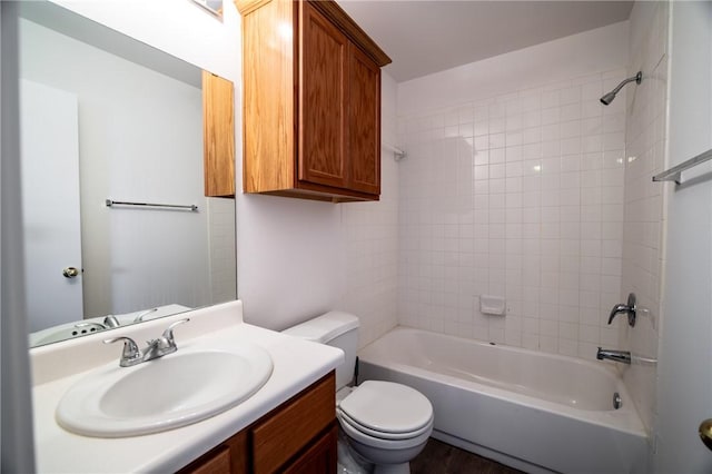 full bathroom with toilet, tiled shower / bath combo, and vanity