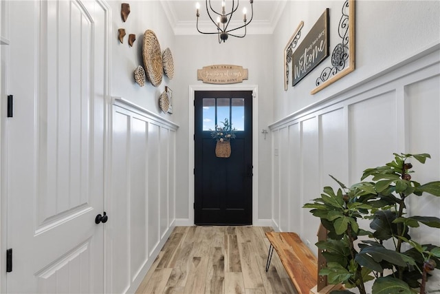 entryway featuring an inviting chandelier, light hardwood / wood-style flooring, and ornamental molding