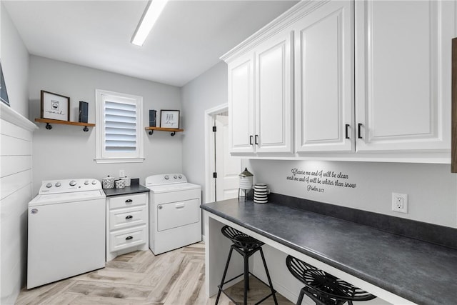 clothes washing area with separate washer and dryer and light parquet floors