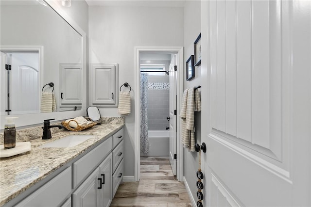 bathroom with wood-type flooring, vanity, and shower / bath combo with shower curtain