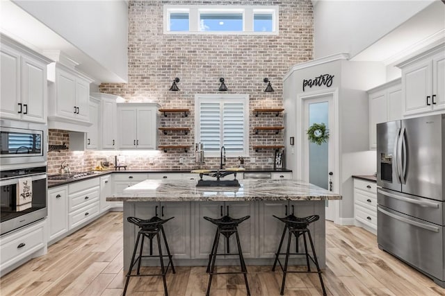 kitchen featuring appliances with stainless steel finishes, white cabinetry, and a breakfast bar area