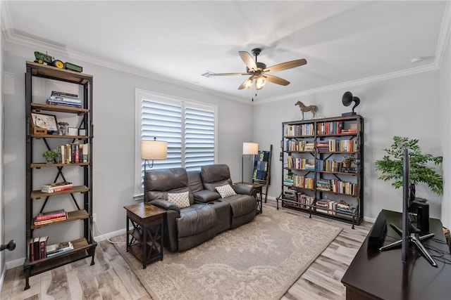 living room featuring light hardwood / wood-style flooring, ceiling fan, and crown molding