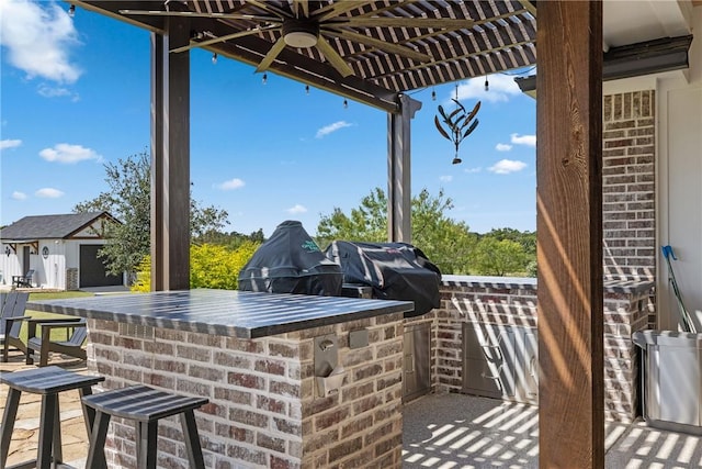 view of patio with an outdoor kitchen, a grill, and a bar