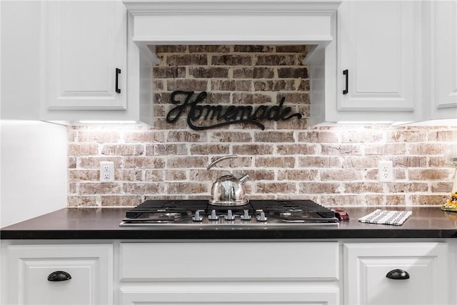 details with decorative backsplash, white cabinetry, and stainless steel gas cooktop