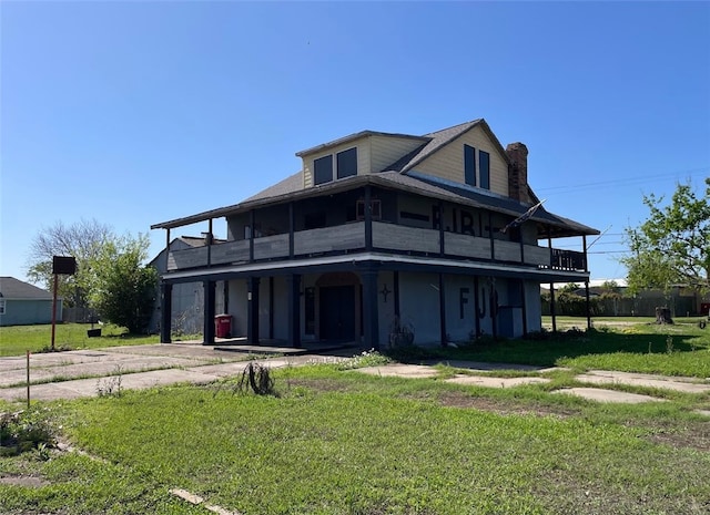 409 S Ave, C, TX 77541 - view of front of property with a balcony, a front lawn, and a chimney