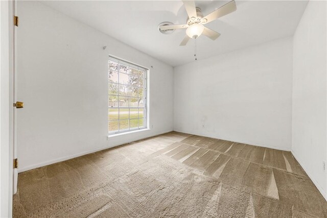 carpeted empty room with a ceiling fan