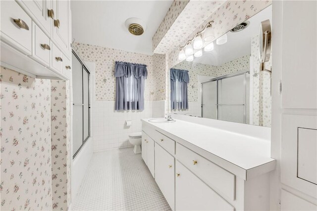 full bathroom featuring tile walls, a wainscoted wall, wallpapered walls, and tile patterned flooring