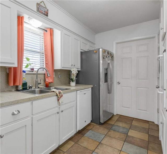 kitchen featuring white dishwasher, white cabinetry, sink, and tasteful backsplash