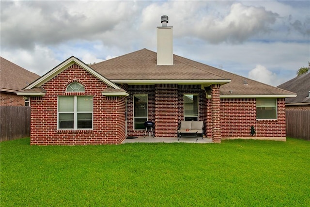 rear view of house with a yard and a patio