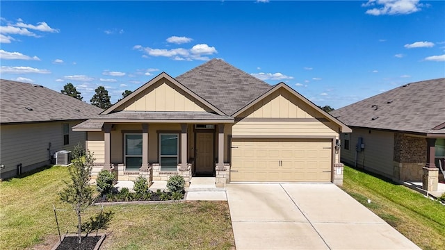 craftsman inspired home with a garage, covered porch, central air condition unit, and a front lawn