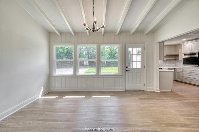 doorway to outside with light hardwood / wood-style floors, beam ceiling, and an inviting chandelier