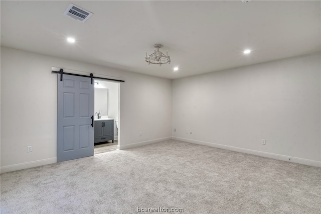 spare room with a barn door and carpet floors